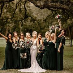 a group of women standing next to each other holding bouquets in front of them