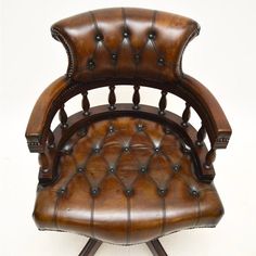 an old fashioned chair with leather upholstered on it