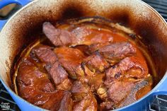 a pot filled with meat sitting on top of a stove