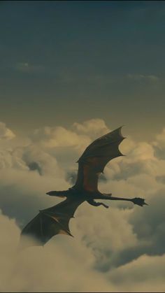 a dragon flying through the sky above some clouds