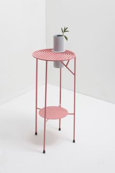 a pink table with a potted plant on top