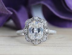 an engagement ring with a large diamond surrounded by smaller diamonds