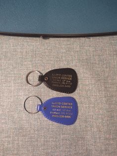 there are two key tags on the back of an airplane seat belt, and one has a leather tag attached to it