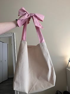 a person holding a bag with a pink bow on it