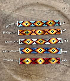 three beaded bracelets sitting on top of a wooden table next to each other