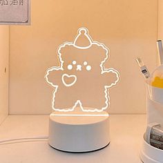 a teddy bear with a party hat on it's head is lit up in the shape of a lamp