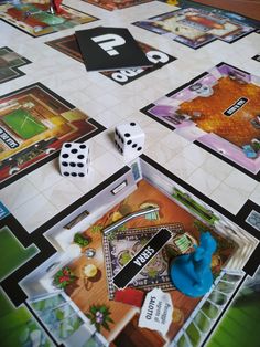 a board game with dices and cards on the floor next to eachother