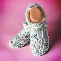 a pair of knitted slippers with a wooden button