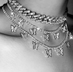 a black and white photo of a woman's chest with multiple chains attached to it