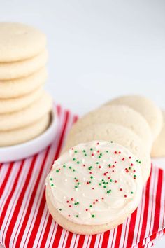 cookies with white frosting and sprinkles on a red and white striped napkin