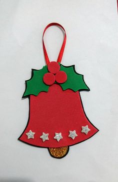 a red and green christmas ornament hanging from a white wall with stars on it