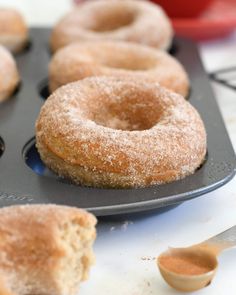 doughnuts sitting in a muffin pan on a table