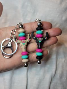 a person holding two key chains in their hand