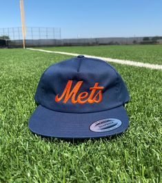 "Grab yourself our fully embroidered vintage style New York Mets unstructured 5 panel hats! This hat is the perfect gift for any Mets fan! This hat features a Lightly-structured, mid-profile. 3¼\" crown, five-panel. Flat bill. Snapback closure. Hat Specs: - Yupoong - 60/40 cotton/polyester blend - Lightly-structured, five-panel, mid-profile - Flat bill - Snapback closure" Retro Flat Bill Hat With Embroidered Logo, Retro Flat Brim Snapback Hat For Baseball Season, Retro Baseball Season Hat With Embroidered Logo, Retro Hat With Embroidered Logo For Baseball Season, Retro Snapback Hat With Embroidered Logo And Curved Brim, Retro Snapback Baseball Cap With Embroidered Logo, Retro Snapback Hat For Baseball Season, Retro Snapback Hat With Embroidered Logo, Retro Embroidered Logo Snapback Baseball Cap