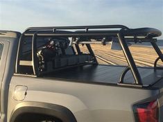 the truck is parked on the beach by the water with its flatbed open and ready to go