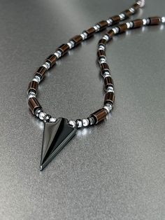 "Masculine Magnetic Necklace with Arrowhead Pendant and Copper Finish Magnetic Tube Beads, with Extra Strength Magnetic Clasp ... One of our most popular men's necklaces!  ~ Available in sizes 18 inches through 23 inches in length.  (21\" shown in photo).  Beads are 6mm in size. // Clasps are Super Strength 8mm.  Hematite Arrowhead is  17x40mm in size. (Also available without Hematite Arrowhead). All of our Magnetic Jewelry features High Quality AAA Grade Magnetic Beads, Extra-strength Neodymium Magnetic Clasps and 90 Pound Strength Copolymer Beading Wire. USPS DOMESTIC SHIPPING Ships domestic USPS First Class within 3-5 Business days  // Please allow 10 Business days from date of purchase to delivery //  Please visit our shop for additional listings: http://www.Etsy.com/shop/StellaMagneti Photo Beads, Arrowhead Pendant, Magnetic Beads, Men's Necklaces, Magnetic Necklace, Super Strength, Magnetic Jewelry, Beading Wire, Copper Finish