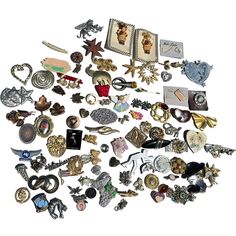 a pile of assorted brooches and pins on a white background with clippings