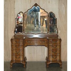 an antique desk with a mirror on it