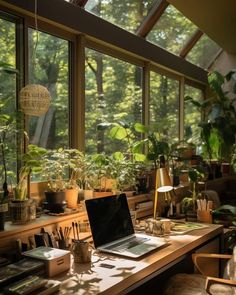 a laptop computer sitting on top of a wooden desk in front of a large window