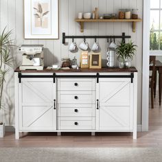 a kitchen with white cupboards and shelves filled with pots, pans and other items