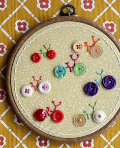 a close up of a sewing board with buttons and flowers on the inside of it