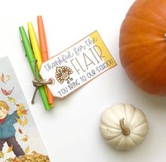 an orange pumpkin next to two children's bookmarks and some other autumn themed items