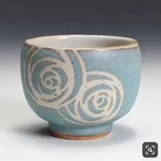 a blue and white cup with swirl designs on it