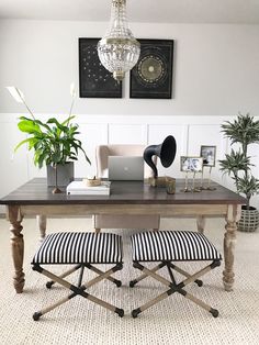 a table with two chairs and a laptop on it in the middle of a room