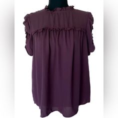 A Maroon Purple Short Sleeve Blouse From Who Wore What. Ruffle Mock Neck With Button Closure In Back. Ruffle Puff Sleeves. Size Small Great Condition, Never Worn Fall Short Sleeve Ruffle Blouse, Fall Blouse With Ruffles And Short Sleeves, Fall Ruffled Short Sleeve Blouse, Fall Ruffles Short Sleeve Blouse, Purple Ruffled Collar Blouse With Ruffles, Purple Ruffle Puff Sleeve Tops, Purple Puff Sleeve Top With Ruffles, Purple Tops With Ruffles And Ruffled Collar, Chic Purple Puff Sleeve Blouse