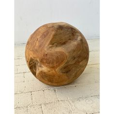 a wooden ball sitting on top of a white tile floor