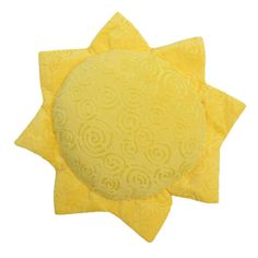 two yellow sun pillows sitting next to each other on top of a white tablecloth