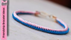 a pink and blue braided bracelet sitting on top of a table