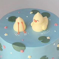 there is a blue cake with two ducks on it