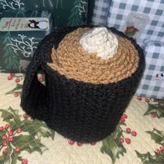 a crocheted tea pot with a lid on a table next to christmas presents