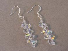 "This beautiful pair of crystals earrings are hand crafted using Swarovski Crystal 6301 Top drilled bicones. This earrings are all Swarovski Crystal AB perfect with most everything all year round. The crystals dangle of the earrings is about 1 1/4\" long and hangs from silver plated earring wires for pierced ears.  Nothing shines as brilliant as Swarovski Crystals.   This a very fun pair of crystal earrings to wear for any occasion and is a great conversation piece. Also makes an unique one of a Crystal Jewelry Earrings, Blue Crystal Bracelet, Bridal Bracelet Pearl, Swarovski Crystal Drop Earrings, Crystals Earrings, Beadwork Designs, Swarovski Crystal Jewelry, Swarovski Crystal Bracelet, Swarovski Bracelet