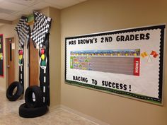 the hallway is decorated with racing themed posters and tire tires for kids to play in