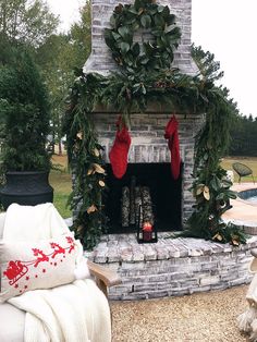 an outdoor fireplace decorated for christmas with stockings on it