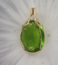 THE BEAUTY OF PERIDOT  --- LAB CREATED  Amazing 40x30  PERIDOT     gemstone----- set in handcrafted  14KT ROLLED GOLD FTHE STONE IS 100 CARATS  gemstone with high detail which cannot be seen in the photograph.  The pendant -- Intricate detail that you can see and notice MEASURES 2 INCHES TALL Very delicate and intricate in appearance and will get you noticed!   One of a kind handcrafted piece of jewelry that anyone will look good in The pendant  is absolutely amazing something that you will be p Elegant Peridot Gemstone Gift, Elegant Peridot Gemstones For Gifts, Elegant Peridot Gemstones As Gift, Classic Green Jewelry With Large Stone, Handmade 14k Gold Green Jewelry, Handmade Green 14k Gold Jewelry, Green Wire Wrapped Jewelry For Anniversary, Classic Handmade Gemstones As Gifts, Classic Handmade Gemstones For Gifts