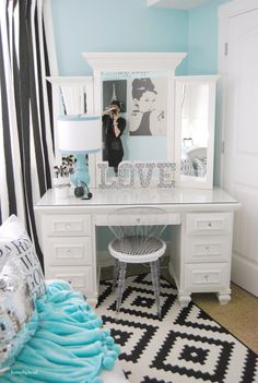 a white desk topped with a mirror next to a black and white rug