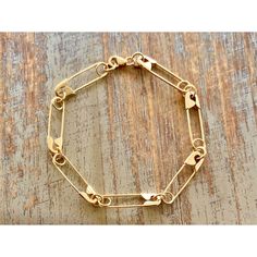 a gold chain bracelet sitting on top of a wooden table