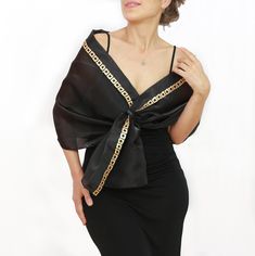 Enhance your formal ensemble with this black dressy shoulder wrap shawl, meticulously crafted from premium satin organza fabric for a touch of sophistication. This slightly transparent shawl features a doubled upper section, designed with a shawl collar-like structure and adorned with your choice of gold or silver sequined trim, offering an exquisite finishing touch. Ideal for mothers of the bride, wedding guests, or any formal occasion, this hands-free evening shawl provides both elegance and comfort.  Available in two sizes to ensure a perfect fit: Standard Size: Suitable for those with an upper body (chest + arms) circumference measurement up to 48.0" (122 cm). XXL Size: Accommodates upper body's around measurements up to 63.8" (162 cm).  The model in the picture is wearing the standard Formal Wrap, Dress Topper, Evening Shawls, Shoulder Wrap, Black Formal, Wrap Shawl, Up Wedding, Organza Fabric, Mother Of The Bride Dress