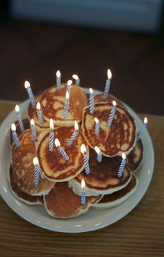 pancakes with lit candles are on a plate