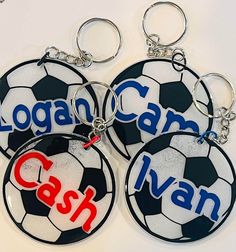 three personalized soccer key chains with the name coach and ball in red, white, and blue