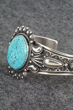 This stunning Kingman turquoise and sterling silver bracelet was made by Navajo silversmith Derrick Gordon. The back is signed Derrick and stamped Sterling.Size: 5 3/8" (will fit up to a 6 1/2" wrist)Gap: 1 1/8"Width: 1 1/2"Cuff Width: 1/2"Free shipping on all orders! We ship with USPS and always include tracking. All orders ship within a day of payment.Returns are accepted up to 30 days after you receive your order. Just send us a message. Our shop offers cash back or store credit. The item mus Southwestern Style Etched Turquoise Jewelry, Southwestern Etched Turquoise Jewelry, Southwestern Turquoise Etched Jewelry, Southwestern Style Stamped Turquoise Bracelets, Southwestern Style Turquoise Stamped Bracelets, Western Style Blue Sterling Silver Collectible Bracelet, Southwestern Style Sterling Silver Turquoise Bracelet, Southwestern Stamped Turquoise Sterling Silver Bracelet, Western Style Blue Sterling Silver Bracelet Collectible