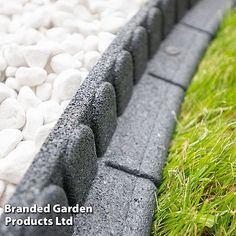 a garden bed with rocks in the middle and grass around it, along with white gravel