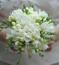 a bride holding a bouquet of white flowers