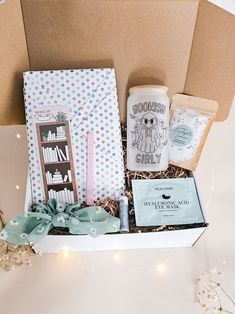 a gift box with books, candles, and other items in it sitting on a table