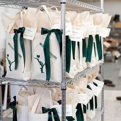 many bags are stacked on the shelves in a store, with ribbons tied around them