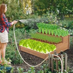 a woman watering her garden with a hose