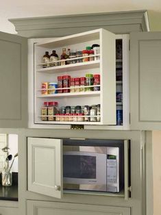 an open cabinet in the middle of a kitchen filled with spices and condiments